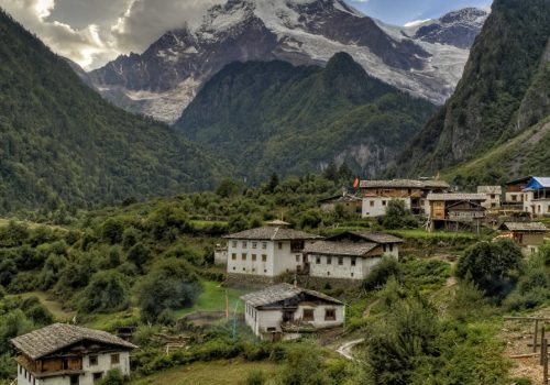 Picturesque village nestled in the Himalayas with lush greenery and towering mountains.