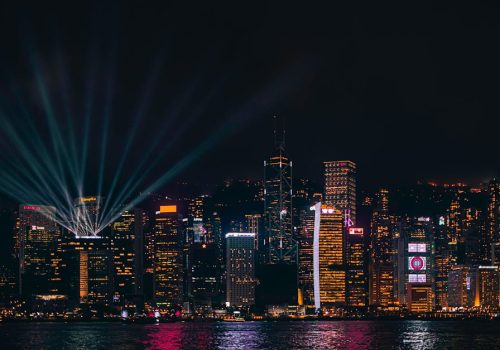 Stunning shot of Hong Kong's illuminated skyline at night, featuring skyscrapers and Victoria Harbour.
