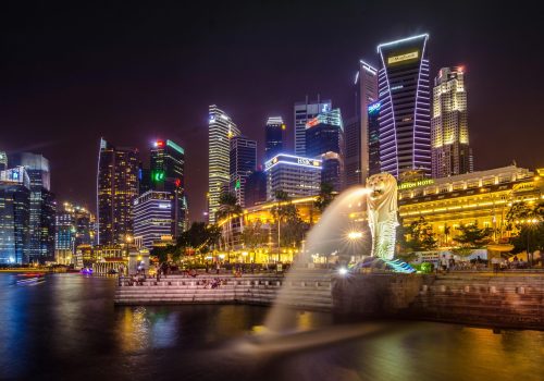 Dazzling view of the Singapore cityscape with Merlion and illuminated skyscrapers at night.