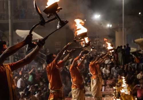Evening Ganga Aarti ceremony at Dasaswamedh Ghat with priests holding flaming torches.